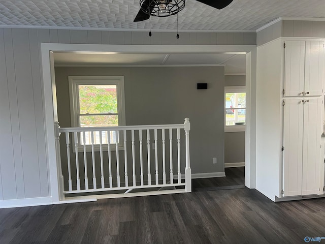 empty room with a wealth of natural light, crown molding, and dark hardwood / wood-style flooring