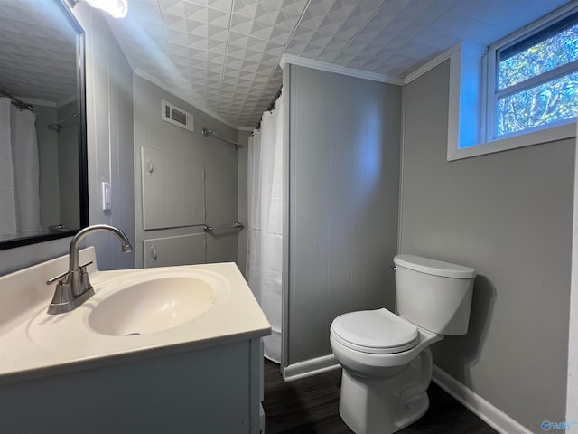 bathroom with toilet, wood-type flooring, ornamental molding, curtained shower, and vanity