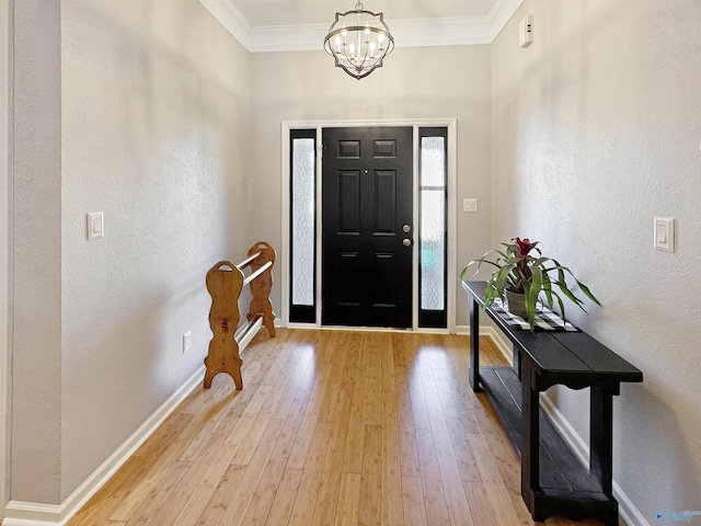 foyer featuring a chandelier, ornamental molding, and light wood-type flooring