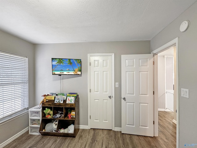 bedroom featuring a textured ceiling and hardwood / wood-style floors