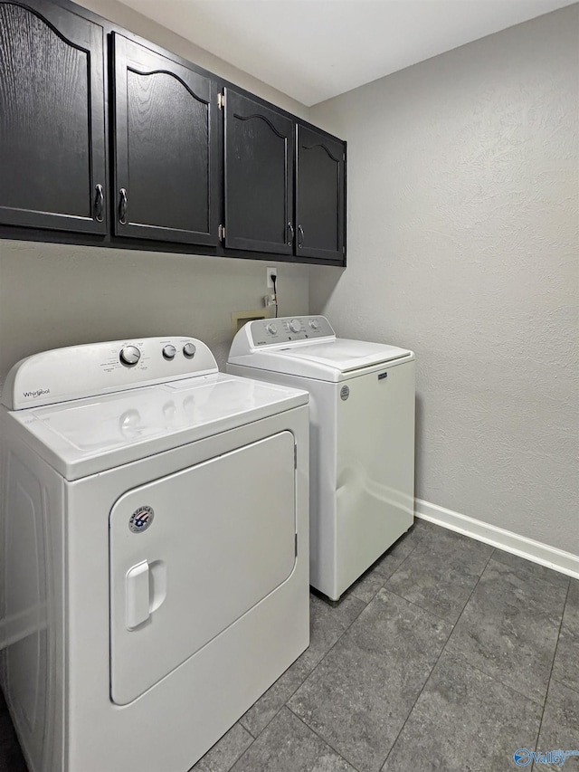 laundry room featuring cabinets, washing machine and clothes dryer, and tile patterned floors