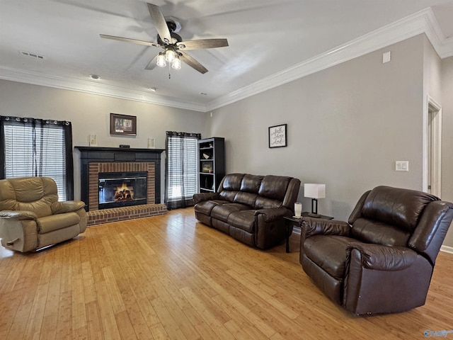 living room with a fireplace, light hardwood / wood-style floors, and crown molding