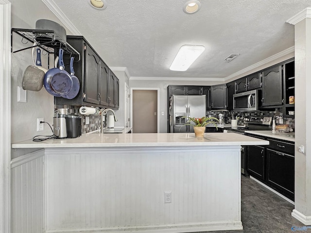 kitchen featuring stainless steel appliances, sink, a textured ceiling, ornamental molding, and kitchen peninsula