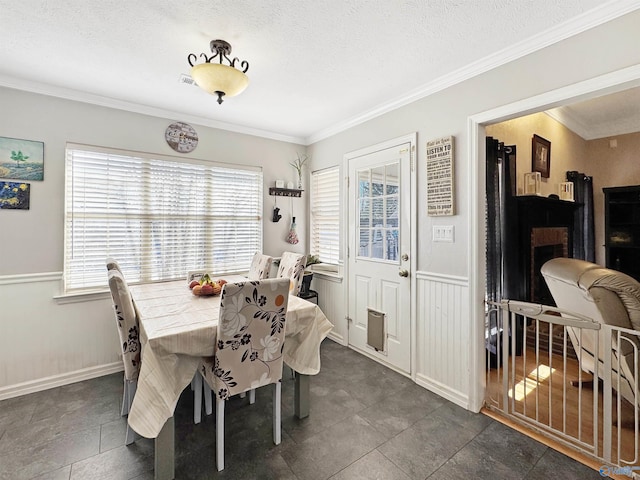 dining area with a textured ceiling, ornamental molding, and a wealth of natural light