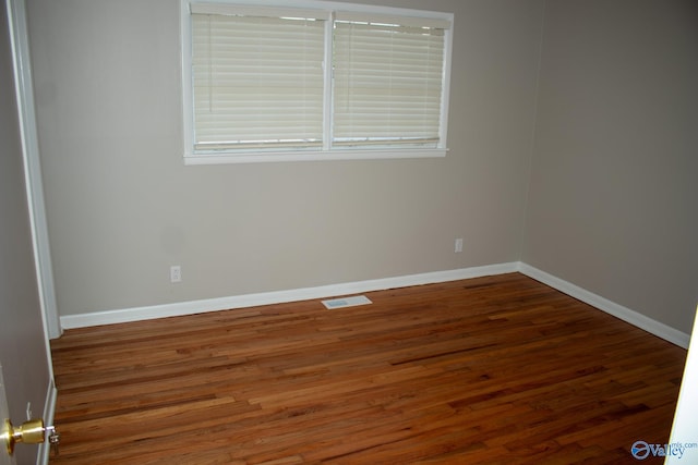 unfurnished room featuring dark wood-type flooring