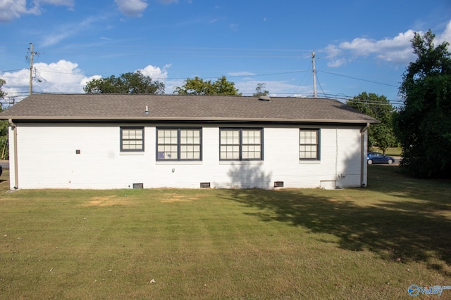 rear view of house featuring a lawn