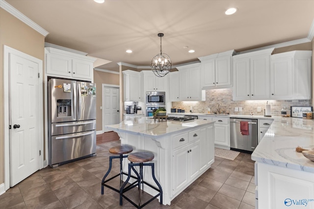 kitchen with a kitchen island, ornamental molding, stainless steel appliances, white cabinetry, and backsplash