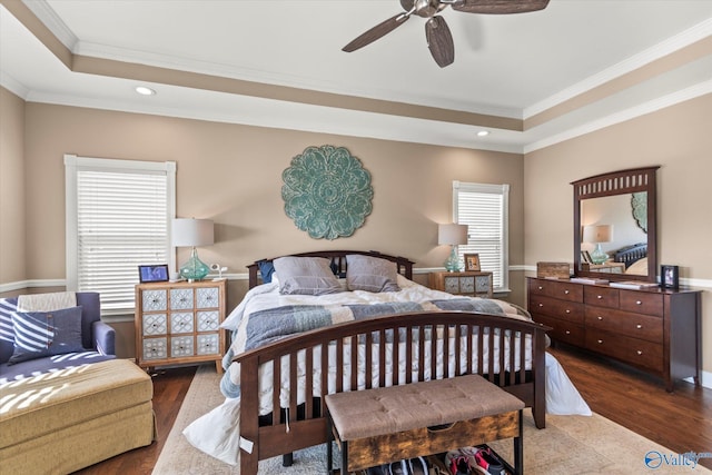 bedroom with recessed lighting, a tray ceiling, wood finished floors, and ornamental molding