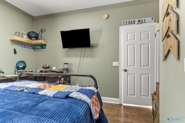 bedroom with ornamental molding, wood finished floors, and baseboards