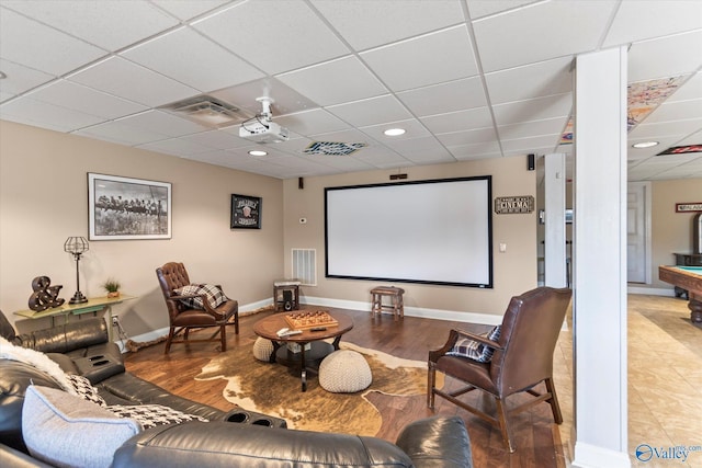 cinema with baseboards, visible vents, a drop ceiling, and wood finished floors