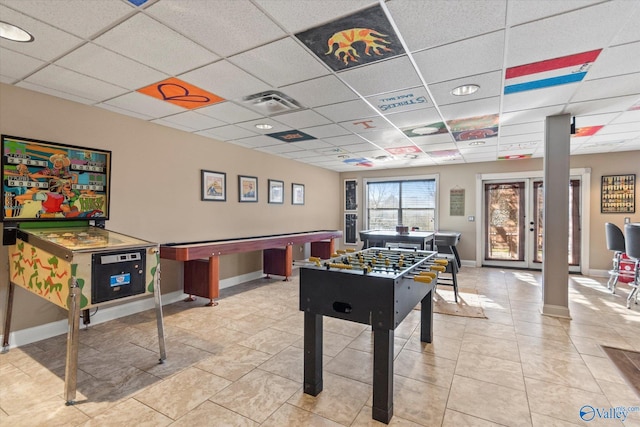 rec room with a paneled ceiling, visible vents, baseboards, and light tile patterned flooring