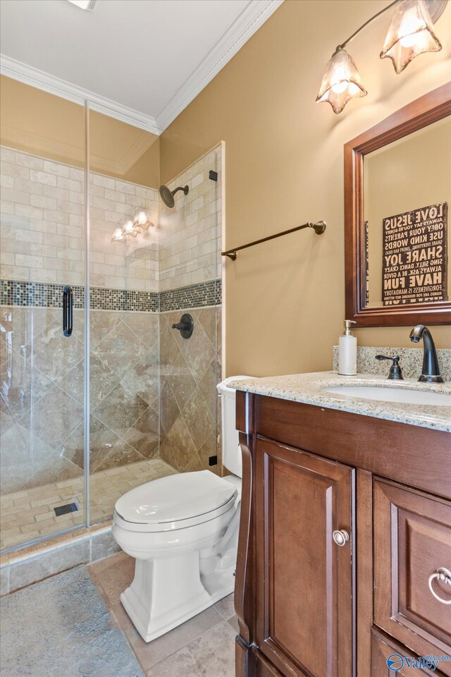 full bathroom featuring ornamental molding, a stall shower, vanity, and toilet