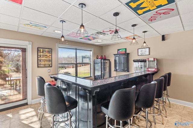 bar featuring a dry bar, baseboards, visible vents, and a paneled ceiling