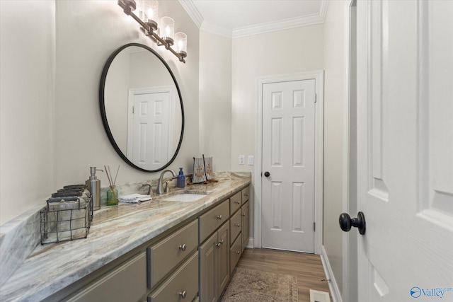 bathroom featuring ornamental molding, wood finished floors, and vanity