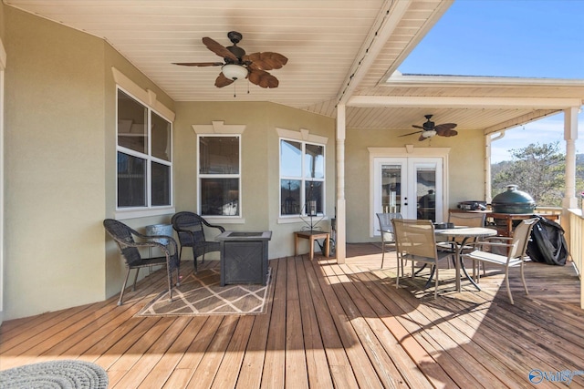 deck with outdoor dining space, ceiling fan, and french doors