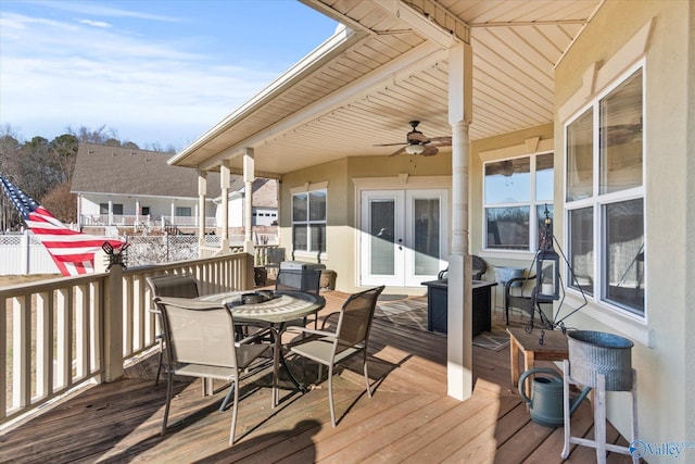 deck with outdoor dining space, french doors, and ceiling fan