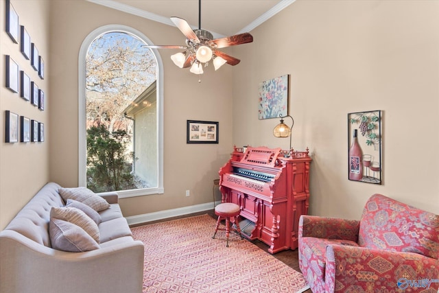 living area featuring ornamental molding, a ceiling fan, a wealth of natural light, and baseboards