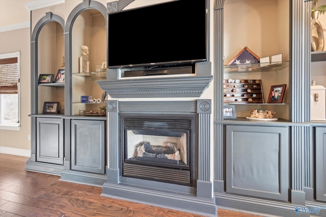 interior space featuring crown molding, baseboards, and wood finished floors