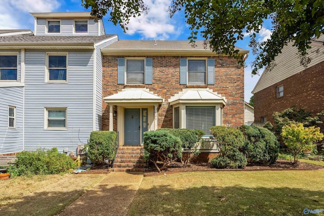 view of front of house with brick siding and a front yard