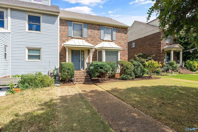 view of front facade with brick siding and a front lawn