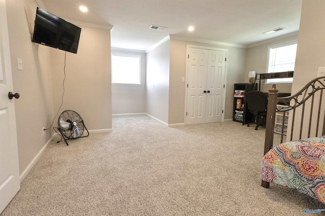 carpeted bedroom featuring baseboards, ornamental molding, and visible vents