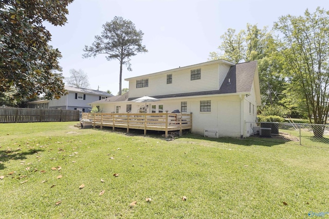rear view of property with a lawn, a shingled roof, a fenced backyard, and a deck