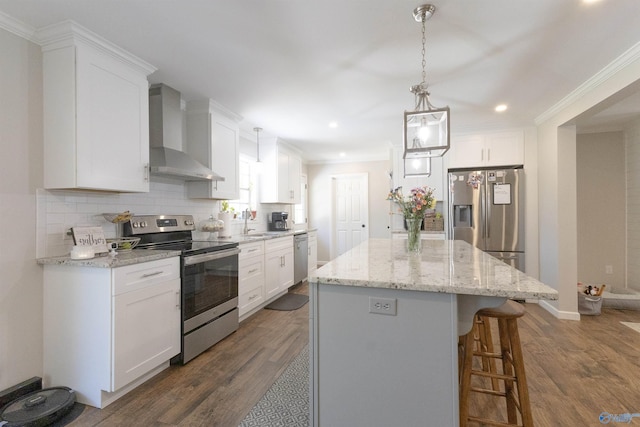 kitchen with a kitchen bar, dark wood finished floors, wall chimney exhaust hood, and stainless steel appliances