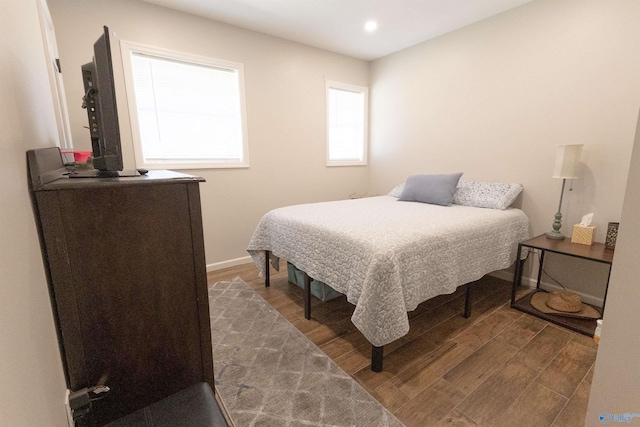 bedroom with baseboards, wood finished floors, and recessed lighting