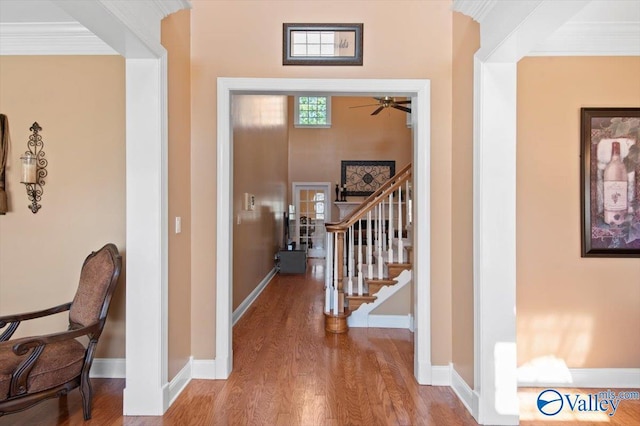 hall with wood finished floors, baseboards, and stairway