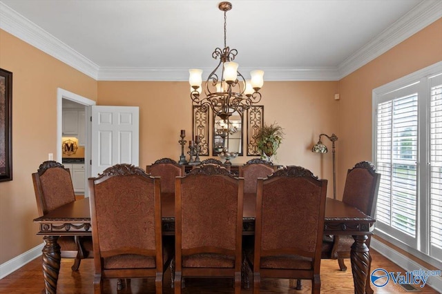 dining area featuring an inviting chandelier, crown molding, light wood-type flooring, and baseboards