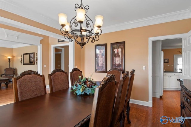 dining area with baseboards, dark wood-style floors, an inviting chandelier, and crown molding