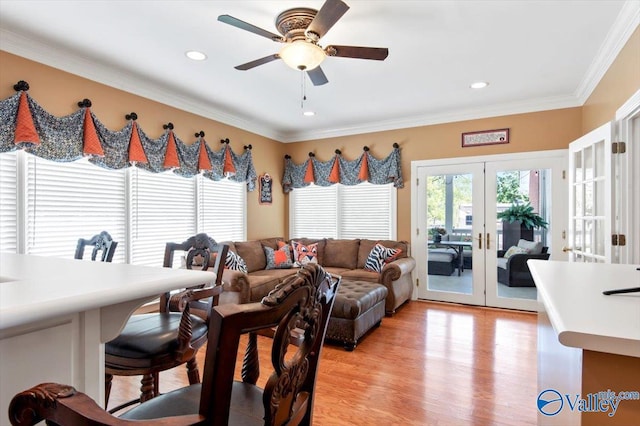 living area featuring a ceiling fan, french doors, crown molding, and light wood-style flooring