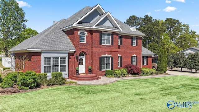 view of front facade featuring brick siding and a front yard