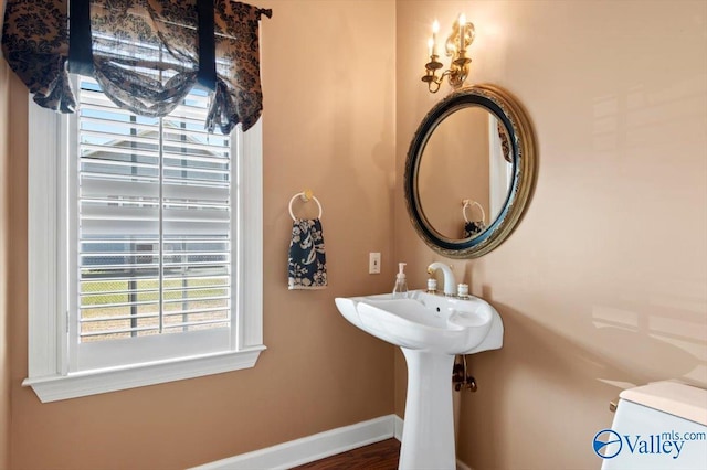 half bathroom with baseboards and plenty of natural light