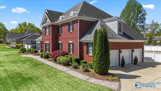 view of home's exterior with fence, a shingled roof, a yard, concrete driveway, and brick siding
