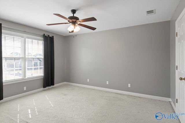unfurnished room featuring visible vents, a ceiling fan, baseboards, and light colored carpet