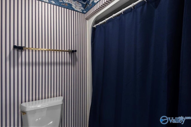 bathroom with wallpapered walls and toilet