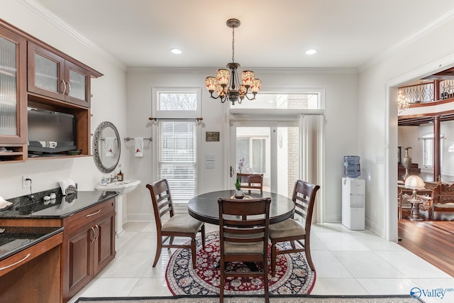 dining room featuring a notable chandelier, light tile patterned flooring, and ornamental molding