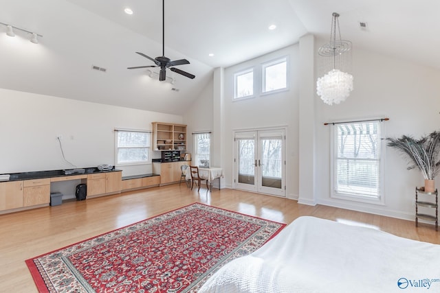living room with french doors, high vaulted ceiling, light hardwood / wood-style floors, and ceiling fan with notable chandelier
