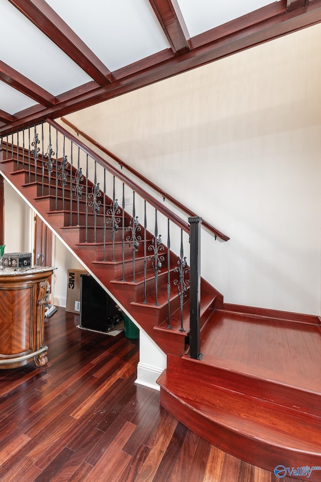 stairs with beamed ceiling and hardwood / wood-style flooring