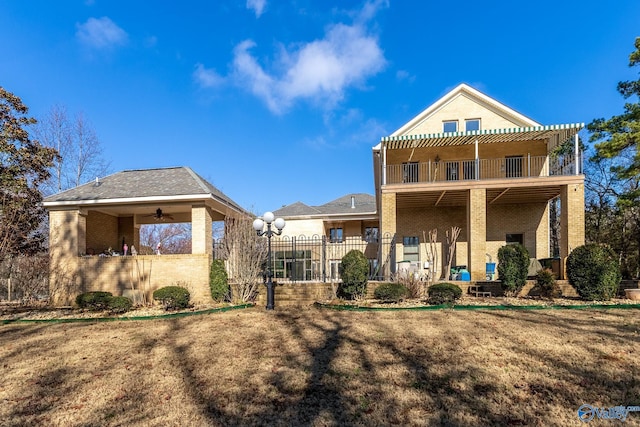 back of house featuring ceiling fan and a balcony