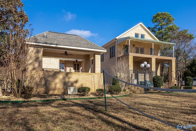 view of front of property featuring ceiling fan and a balcony