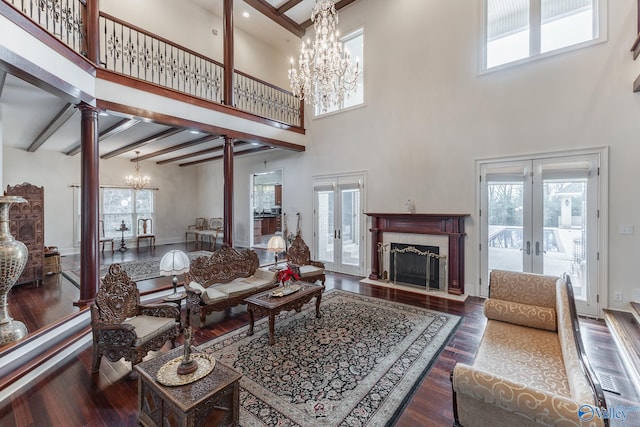 living room with beamed ceiling, french doors, a towering ceiling, and dark hardwood / wood-style floors