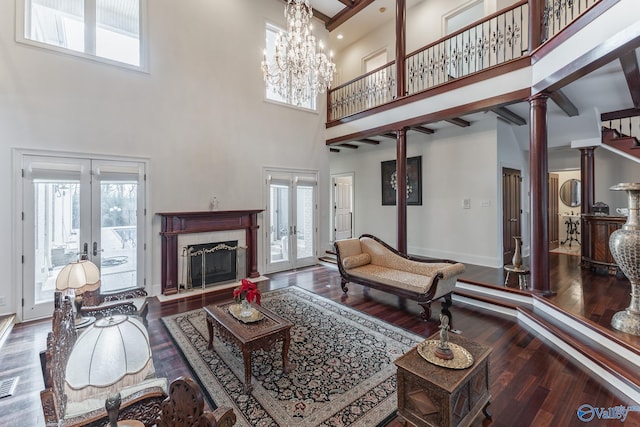 living room with french doors, ornate columns, a healthy amount of sunlight, and a high ceiling