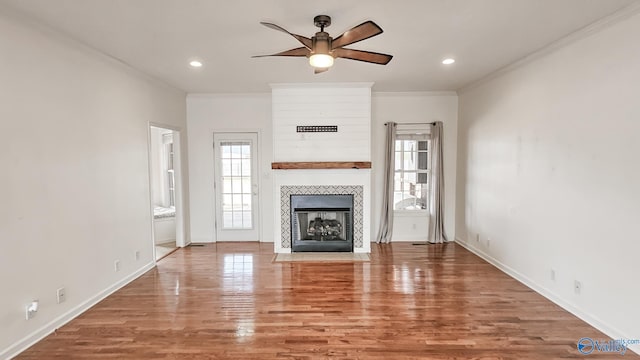 unfurnished living room with recessed lighting, a fireplace, wood finished floors, and crown molding