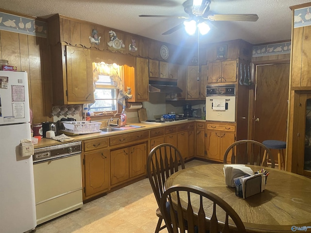 kitchen with sink, white appliances, a textured ceiling, and ceiling fan