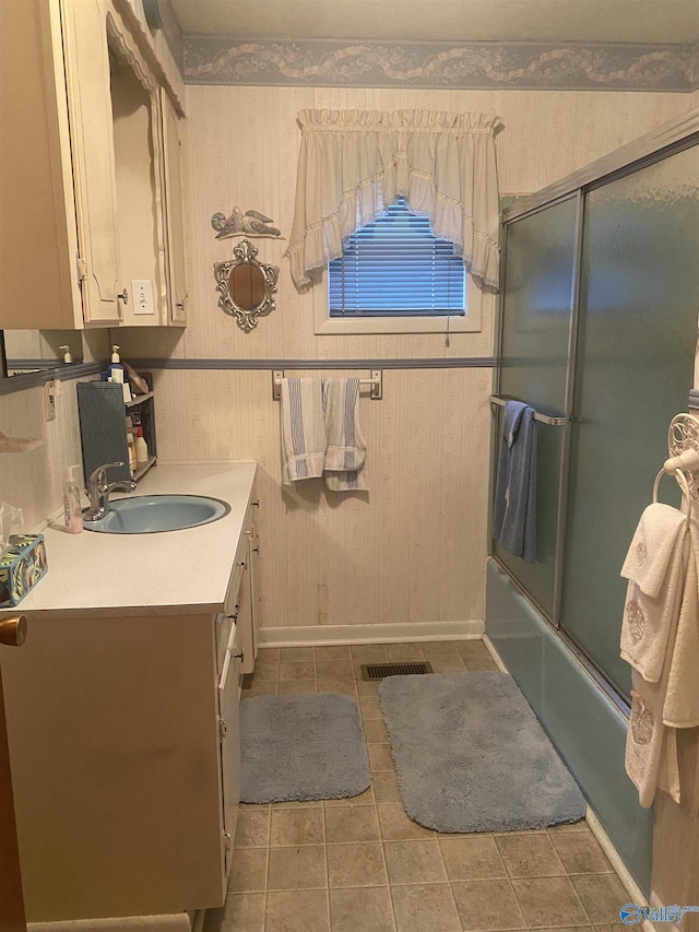 bathroom featuring tile patterned floors, vanity, and combined bath / shower with glass door