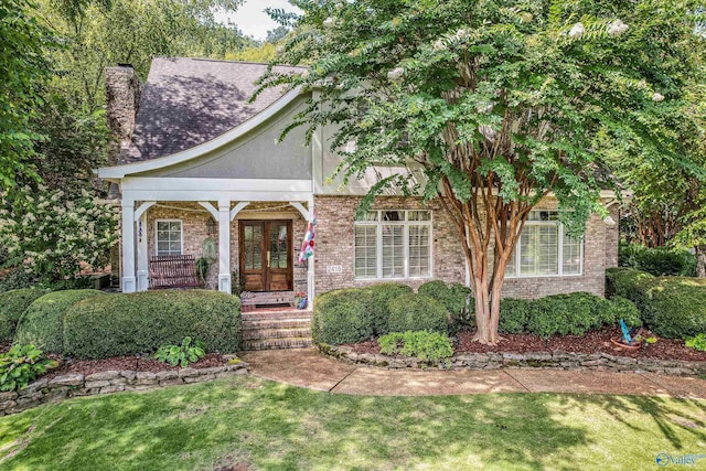 view of front of property with a front yard and french doors