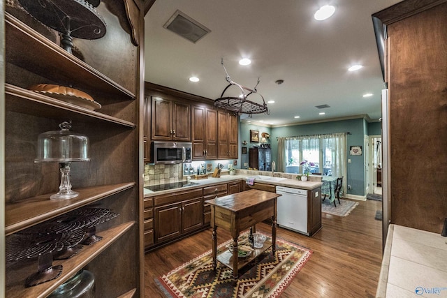 kitchen with crown molding, dark wood-type flooring, black electric stovetop, and dishwashing machine