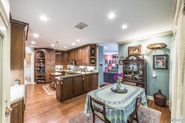 kitchen with crown molding and light wood-type flooring